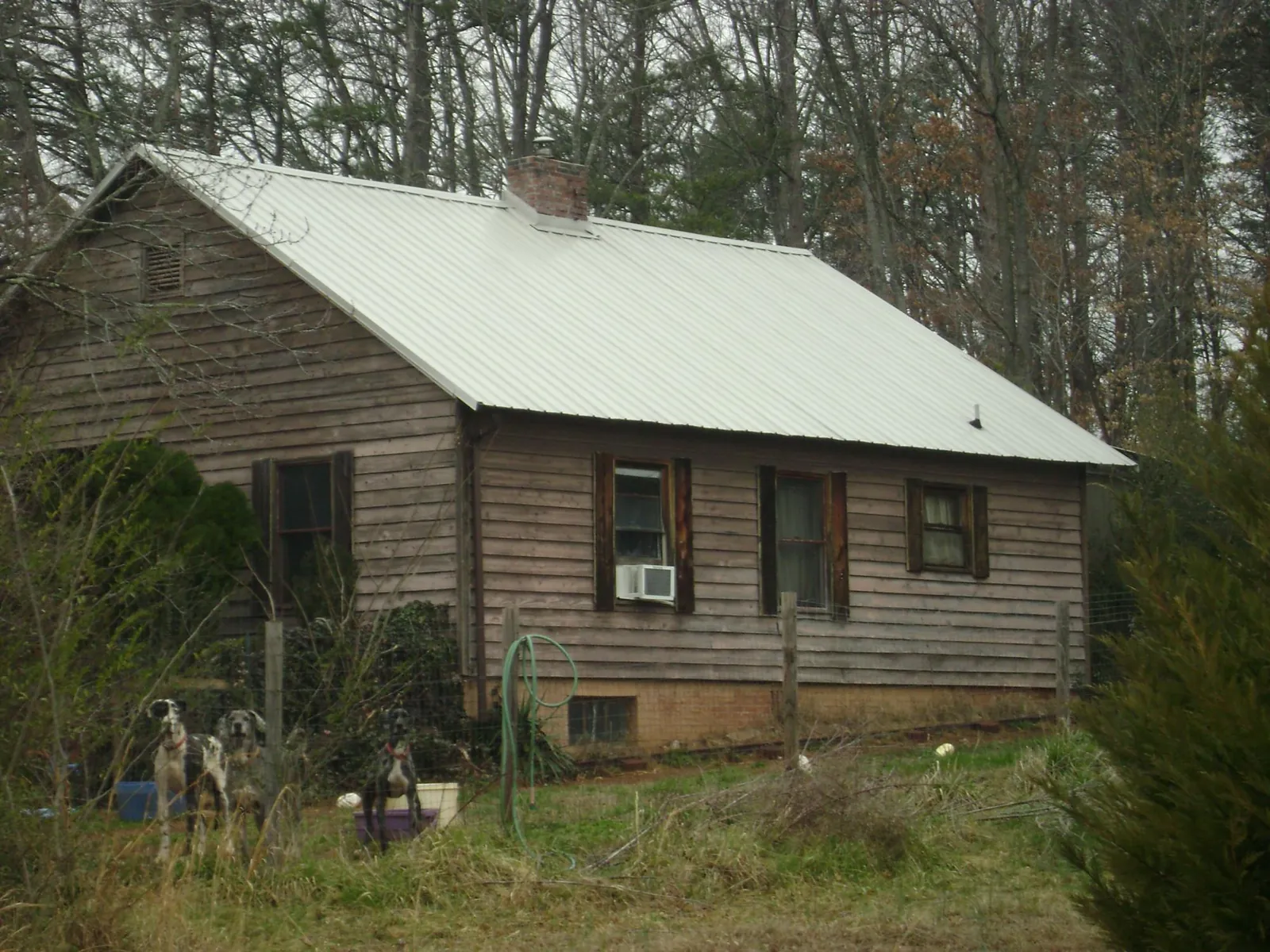 White metal roof on an old wood sided farmhouse, from a Metal Roof Installation job in Mansfield
